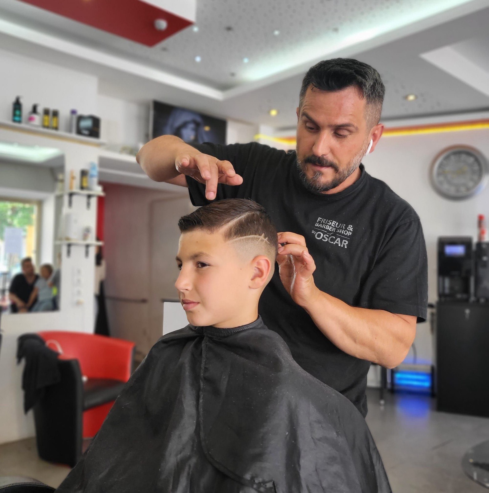 Alexander, Inhaber von Oscar Alex Barbershop, bei der Arbeit am Kunden