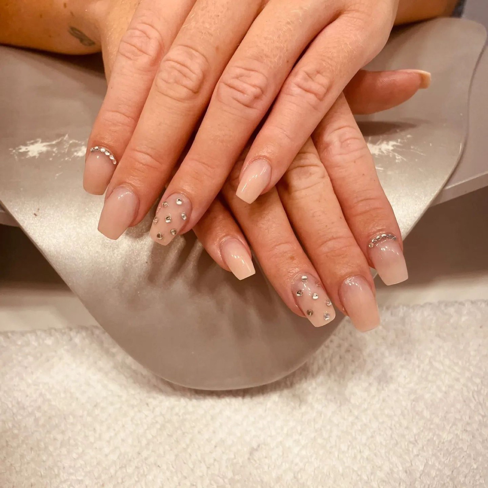 Nageldesign in Nude-Tönen mit dezenten Steinchen